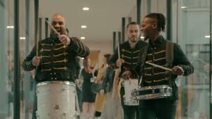 a group of smiling men in uniform playing drums at a corporate event in the carton house, Kildare, Ireland, representing Empire Productions entertainment company.